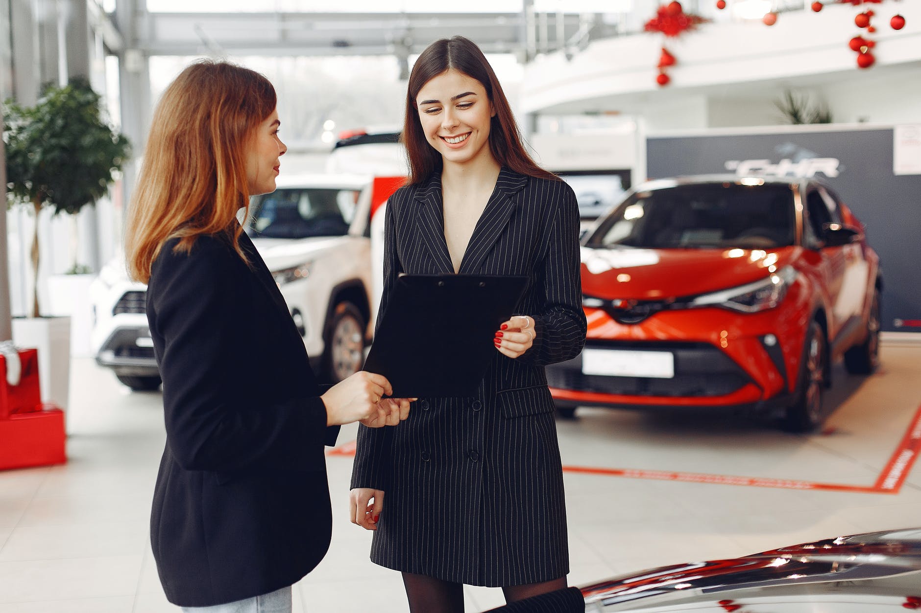 positive gorgeous agent sharing contract with client in car salon